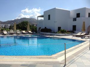 a large swimming pool with chairs and a building at Astir Of Naxos in Naxos Chora