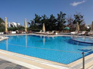 a large swimming pool with chairs and umbrellas at Astir Of Naxos in Naxos Chora