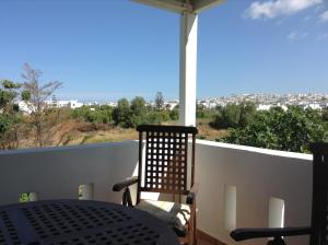 a balcony with a table and a view of a city at Astir Of Naxos in Naxos Chora
