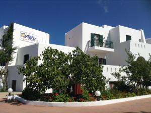 a white building with a tree in front of it at Astir Of Naxos in Naxos Chora