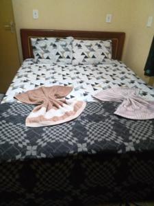 a bed with two pairs of slippers on it at RECANTO DO SABIÁ in Carolina