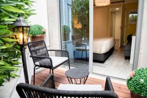 Cette chambre dispose d'une terrasse avec des chaises et d'un lit. dans l'établissement Kavia Hotel do Largo, à Cascais