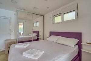 een slaapkamer met een groot bed en een spiegel bij Odore di Mare in Utjeha
