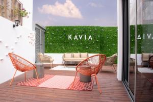a patio with chairs and a table and a green hedge at Kavia Hotel do Largo in Cascais