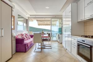kuchnia i salon z fioletową kanapą w obiekcie Odore di Mare w mieście Utjeha