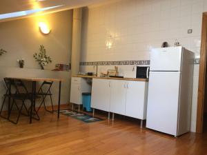 a kitchen with a white refrigerator and a table at Casa Morrosco in Molinaseca