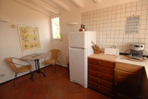 a kitchen with a white refrigerator and a table at Casa di Jo in Imperia