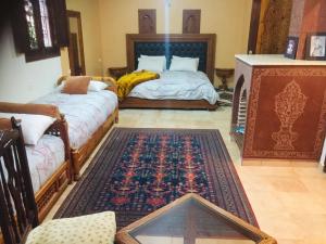 een woonkamer met 2 bedden en een tapijt bij Flashback House in Marrakesh