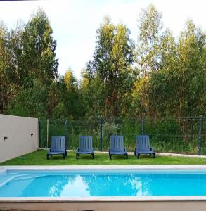 four blue chairs sitting next to a swimming pool at Casa dos Matos in Ponte de Lima