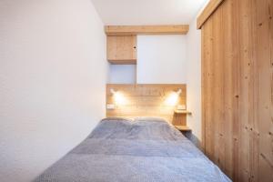 a bedroom with a bed with a wooden wall at Nice Apt With Mountain View At The Foot Of Slopes in Chamonix-Mont-Blanc