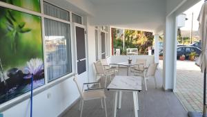 a patio with tables and chairs and a window at Villa Irida in Sarti