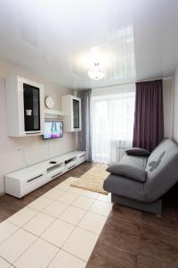 a living room with a couch and a flat screen tv at Центр. Вулиця Руська. 2 кімнати in Ternopilʼ