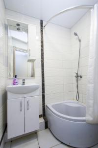 biała łazienka z wanną i umywalką w obiekcie Центр. Вулиця Руська. 2 кімнати w mieście Tarnopol