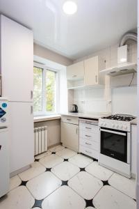 a kitchen with white cabinets and a black and white tiled floor at Центр. Вулиця Руська. 2 кімнати in Ternopilʼ