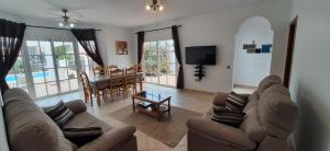 a living room with a couch and a television and a table at Golf Villa Mira With Private Pool in Costa de Antigua