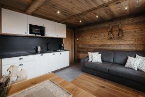 a living room with a couch and a kitchen at Chalet Rich in Val Badia in San Martino in Badia