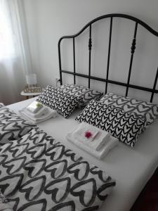 a bed with black and white sheets and pillows at Babalina's Place in Bihać