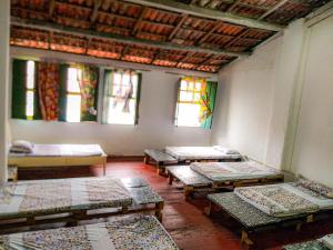 a room with rows of beds and stained glass windows at Hostel Ateliê Laroyê in Salvador