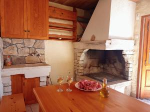 une cuisine avec une table avec des verres à vin et une cheminée dans l'établissement Apartman Luka, à Blato
