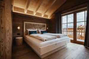 a bedroom with a bed in a room with wooden walls at Chalet Rich in Val Badia in San Martino in Badia