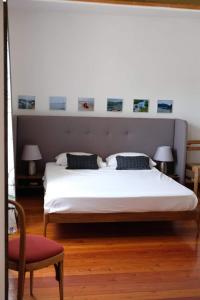 a bedroom with a large white bed and a chair at La casa dei ciclisti in Ponti Sul Mincio