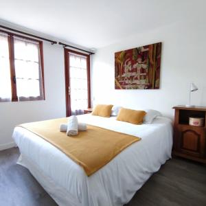 1 dormitorio con 1 cama blanca grande y 2 almohadas en Chalet les falaises, en Saint-Léonard