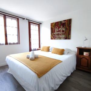 a bedroom with a large white bed with two pillows on it at Chalet les falaises in Saint-Léonard