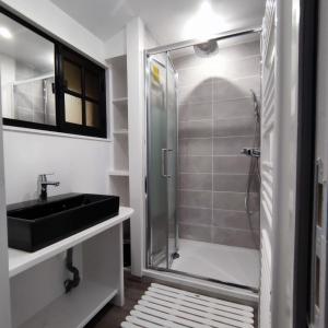 a bathroom with a shower and a sink at Chalet les falaises in Saint-Léonard