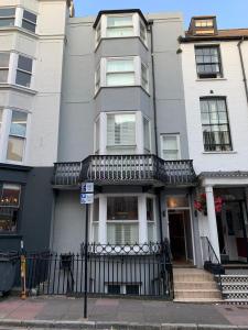 a white building with a balcony on a street at Weslie Guest House in Brighton & Hove