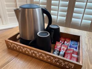 a wooden tray with a coffee pot and cups on a table at Weslie Guest House in Brighton & Hove