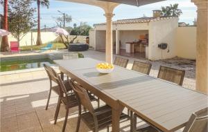 マルセイヤンにあるStunning Home In Marseillan With 3 Bedrooms, Wifi And Outdoor Swimming Poolの木製テーブルと椅子付きのパティオ