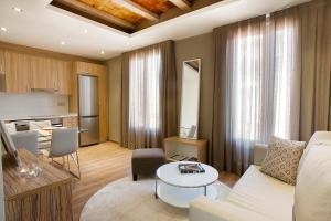 バルセロナにあるバルセロナ アパートメント ミラのリビングルーム(白いソファ付)、キッチンが備わります。