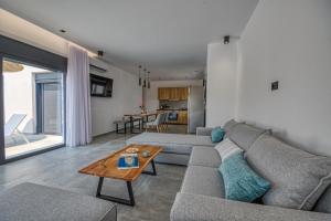 een woonkamer met een bank en een tafel bij Terra Secreta Luxury Villas in Lardos