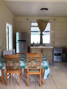 波拉波拉的住宿－Toa Lodge Bora Bora，厨房配有桌子、两把椅子和冰箱