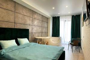 a bedroom with a bed and a tub in a room at Arkadiya Sky Jakuzi & MP 25 in Odesa