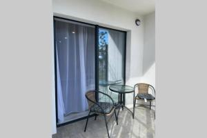 a balcony with a glass table and chairs on it at Arkadiya Sky Jakuzi & MP 25 in Odesa +37 photos