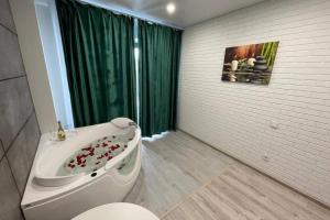 a bathroom with a toilet and a sink and a tub at Arkadiya Sky Jakuzi & MP 25 in Odesa