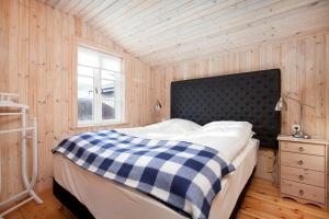 a bedroom with a bed with a black and white checkered blanket at Hotel Dimon in Stora Mork