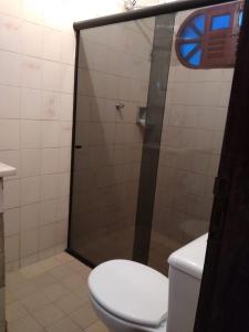 a bathroom with a toilet and a glass shower at Casa no centro de Bananeiras PB in Bananeiras