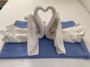 two swans shaped towels sitting on top of a bed at Apartments Michael & Petra , Omisalj, Insel Krk, Kroatien in Omišalj