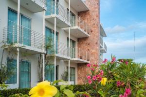 a building with balconies and flowers in front of it at Hotel Noor in Chetumal