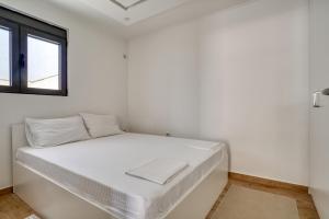 a white bed in a room with a window at Villa Krofnica in Ulcinj