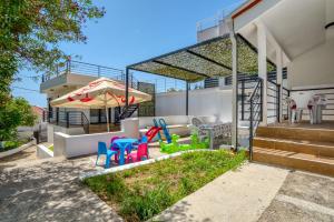 a backyard with colorful chairs and an umbrella at Villa Krofnica in Ulcinj