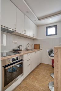 a kitchen with white cabinets and a sink at Villa Krofnica in Ulcinj