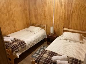 sypialnia z 2 łóżkami i lampką na stole w obiekcie Puesto Cánogas Hostal w mieście Villa O'Higgins