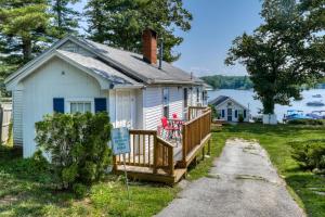 ein kleines weißes Haus mit einem Schild davor in der Unterkunft Bayview Cottages & Retreats in Standish