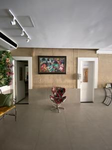 a room with a chair and a painting on the wall at Aton Plaza Hotel in Goiânia