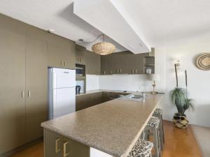 a kitchen with a counter top and a refrigerator at The Rocks Resort Unit 3D in Gold Coast