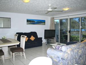 a living room with a couch and a table and a tv at Riverview Unit 6 in Gold Coast