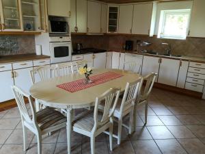 a kitchen with a table with white cabinets and a table and chairs at Wannborga Vingård in Köpingsvik +20 photos